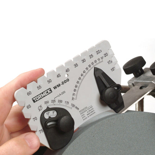 An operator uses the AngleMaster to check that the plane blade is being sharpened at 25 degrees on a 250mm diameter wheel.