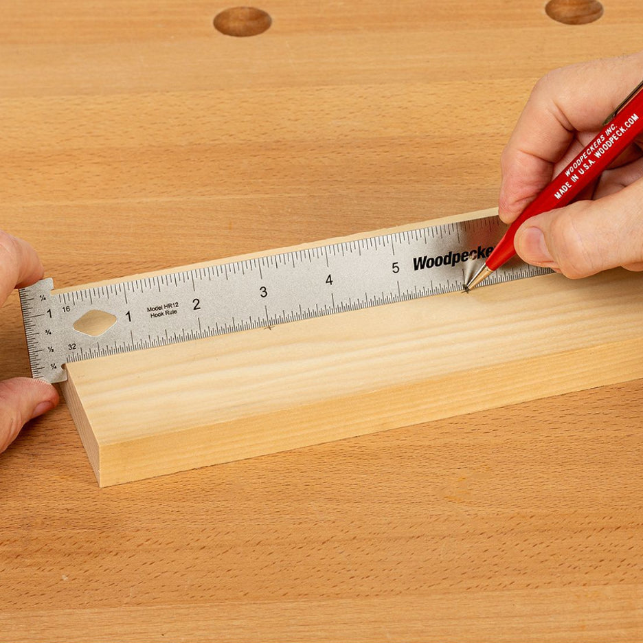 Woodpeckers Hook Rule set against end of wood board and distance marked with pencil.