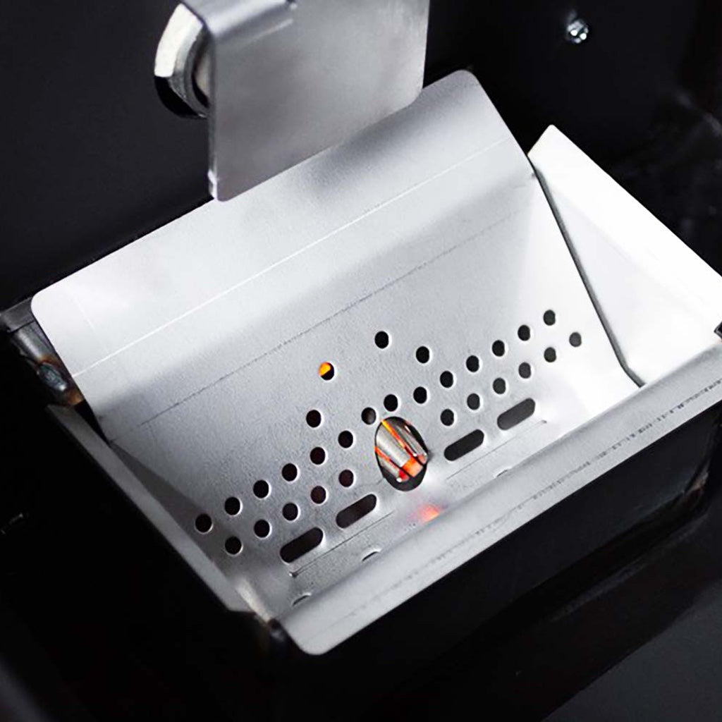 The metal shroud covering the ceramic igniter peeks through the pellet grate.