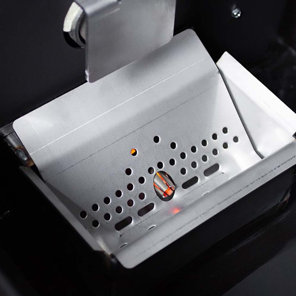 The metal shroud covering the ceramic igniter peeks through the pellet grate.