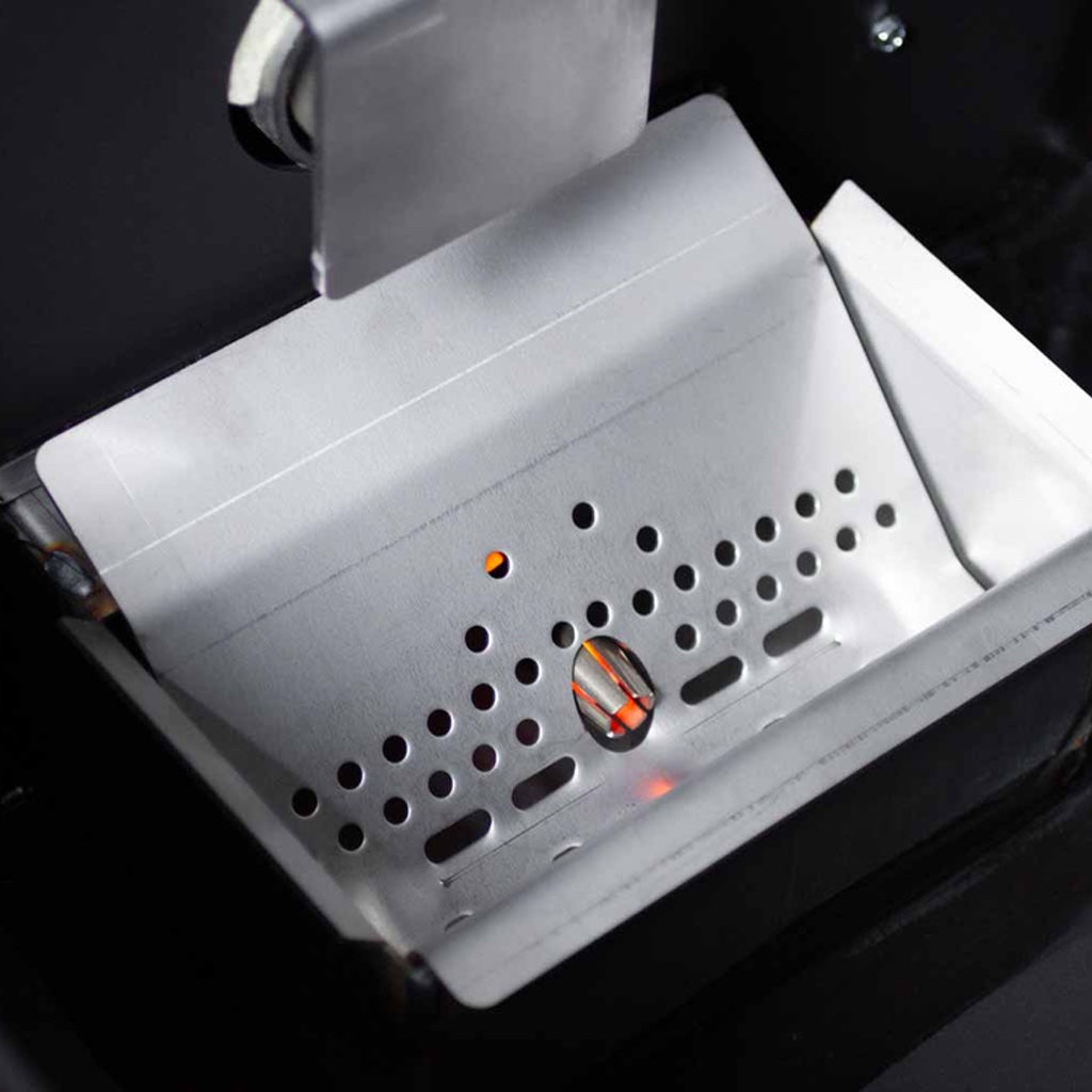 The metal shroud covering the ceramic igniter peeking through the pellet grate.