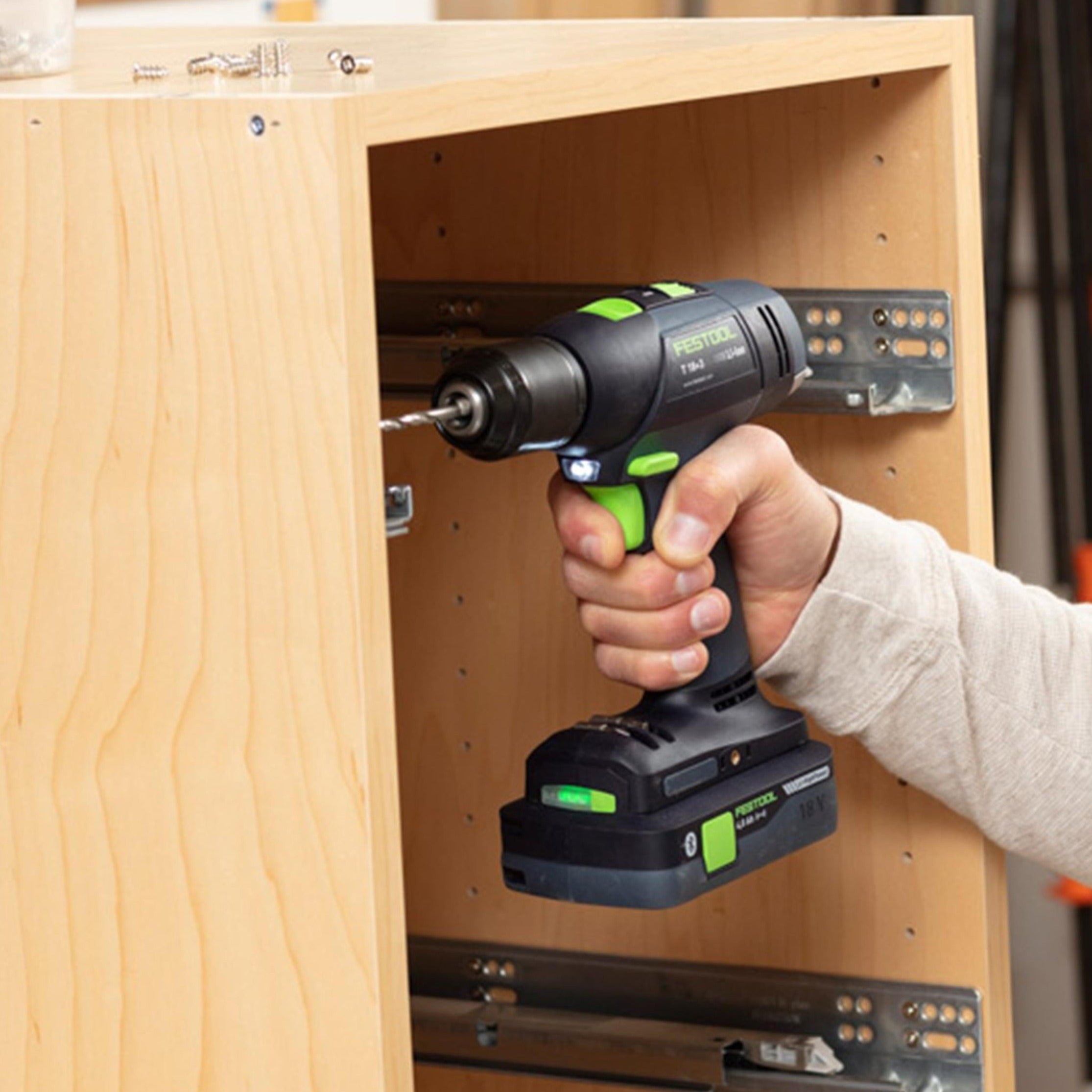 A cabinetmaker uses the T 18 Easy to install drawer slides with system screws in a narrow maple cabinet.
