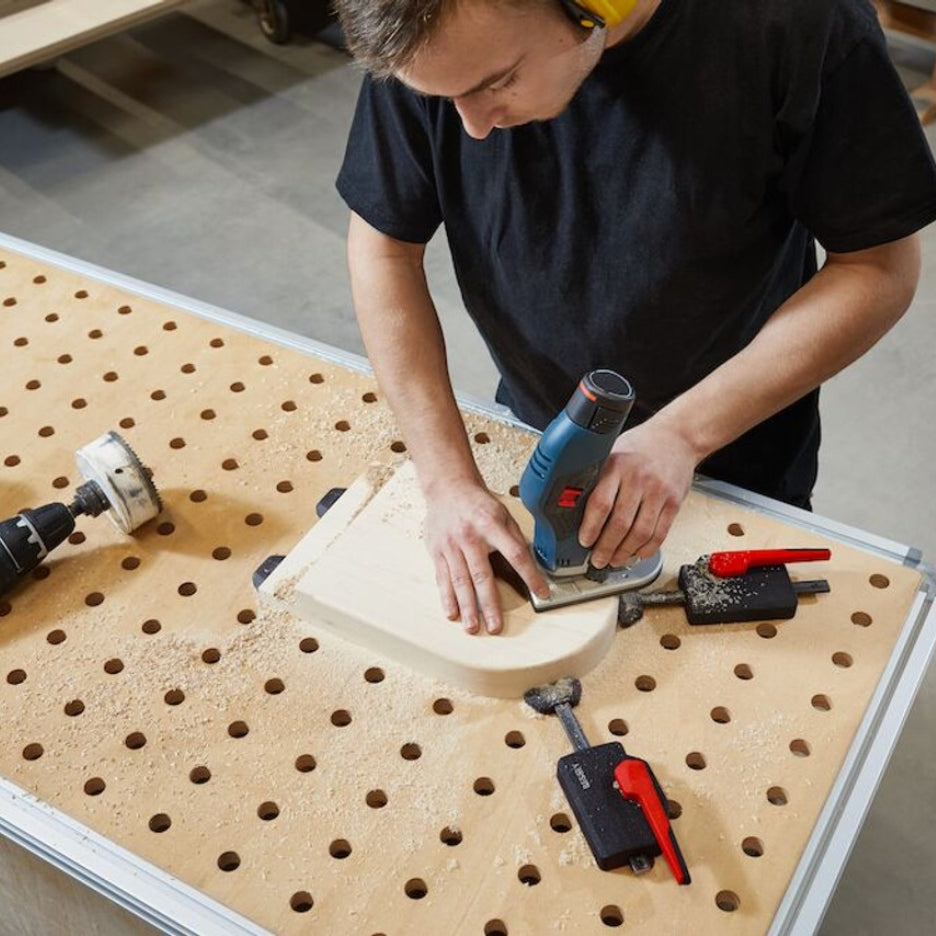 Man finishing work while Bessey Tools Horizontal Table Clamp Fixture holds it in place