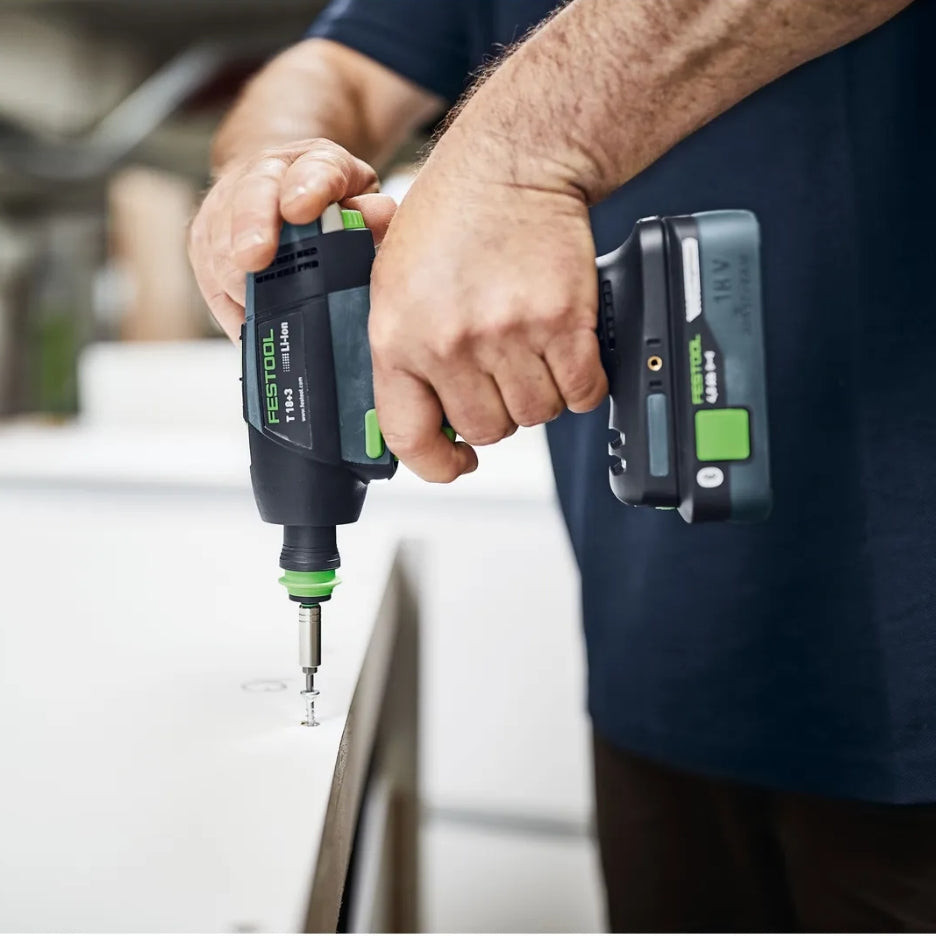 Person using a Festool Cordless Drill T 18+3 on a blurred background