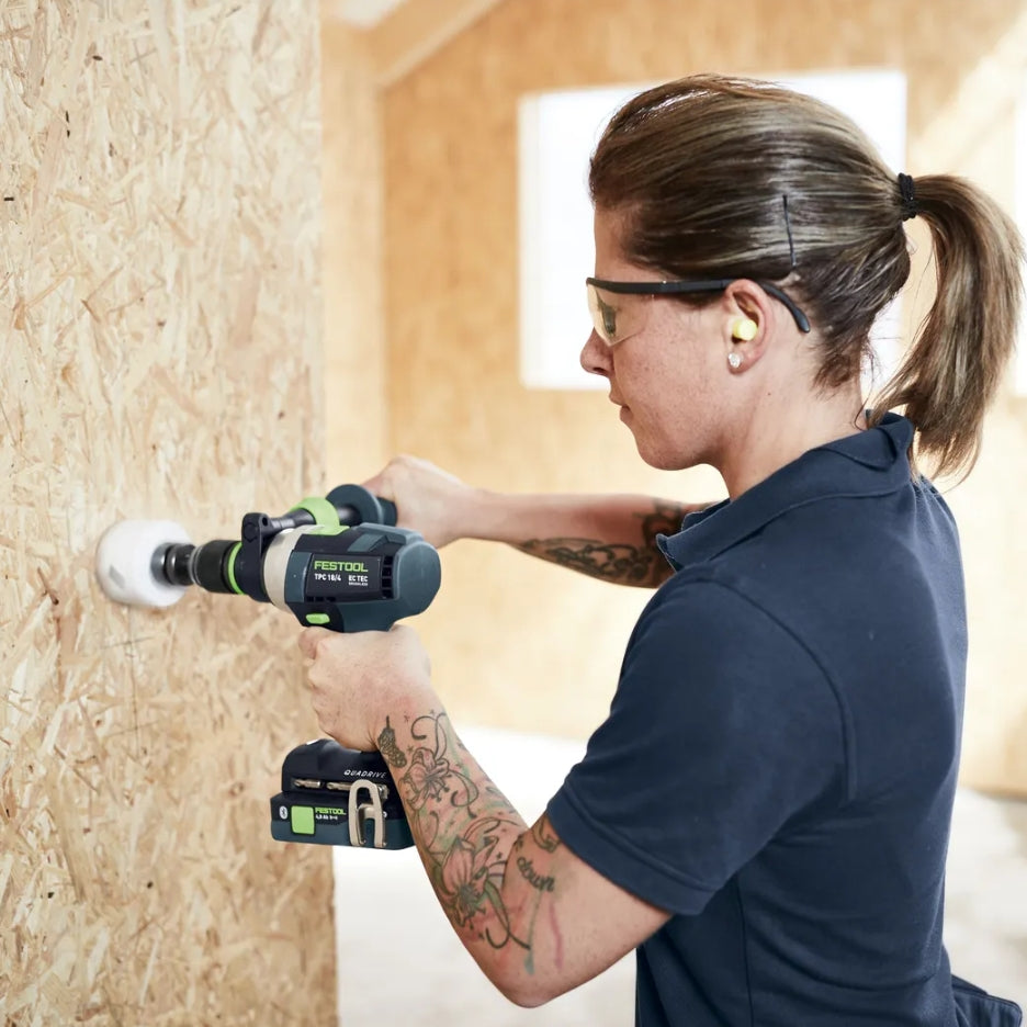 Woman using Festool Cordless Hammer Drill TPC 18/4l on a wooden wall