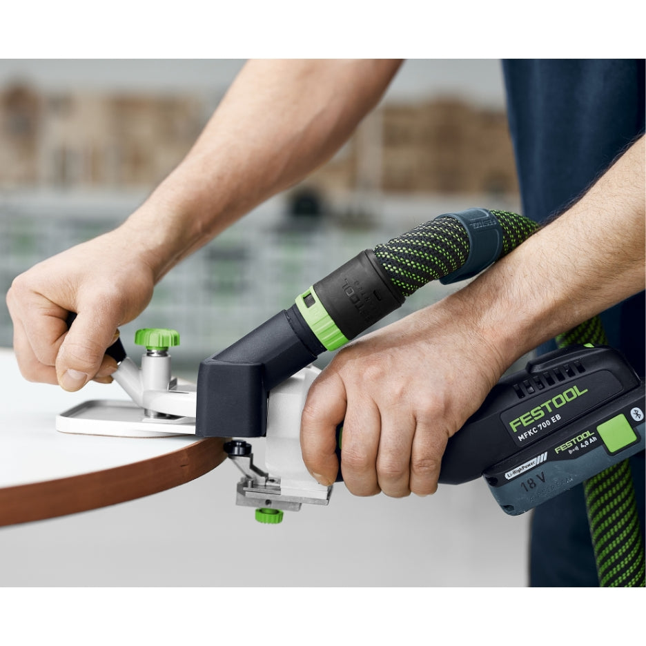 A person using the Festool MFKC 700 EB router to perform a decorative edge profile on a circular table edge