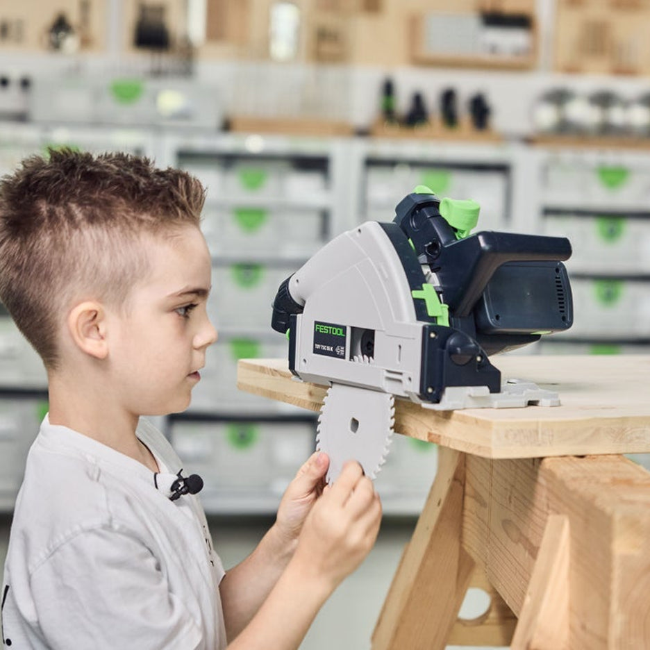 Boy changes the blade of his toy Festool track saw.