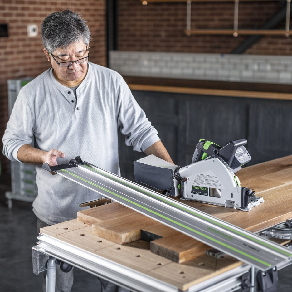 Man holding guide rail and Festool Cordless Track Saw 160mm TSC 55 KEB-F-Basic by his side
