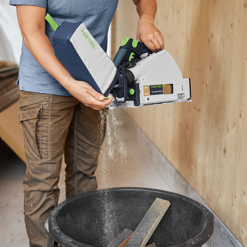 Man empties Festool dust bag attached to cordless track saw over garbage bin