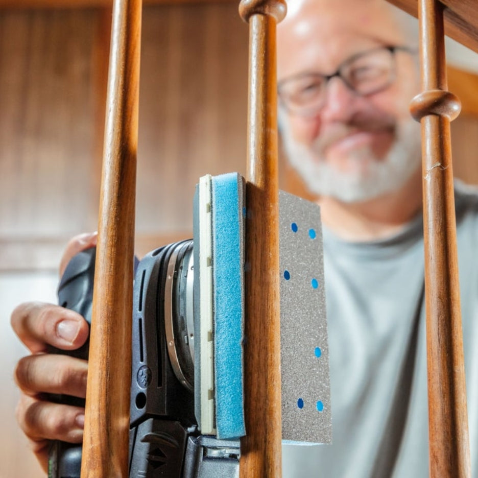 Man using Festool sander with Festool Grit Abrasives Granat PROfile 80x133 M GR PRO to sand a staircase railing 