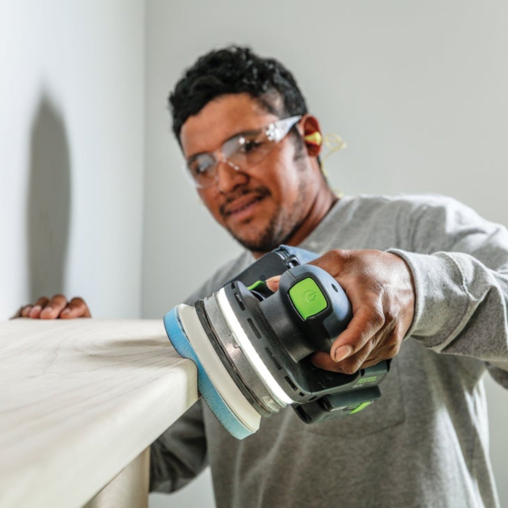 Man using Festool sander with Festool Grit Abrasives Granat PROfile D125 M GR PRO to sand wooden mantel