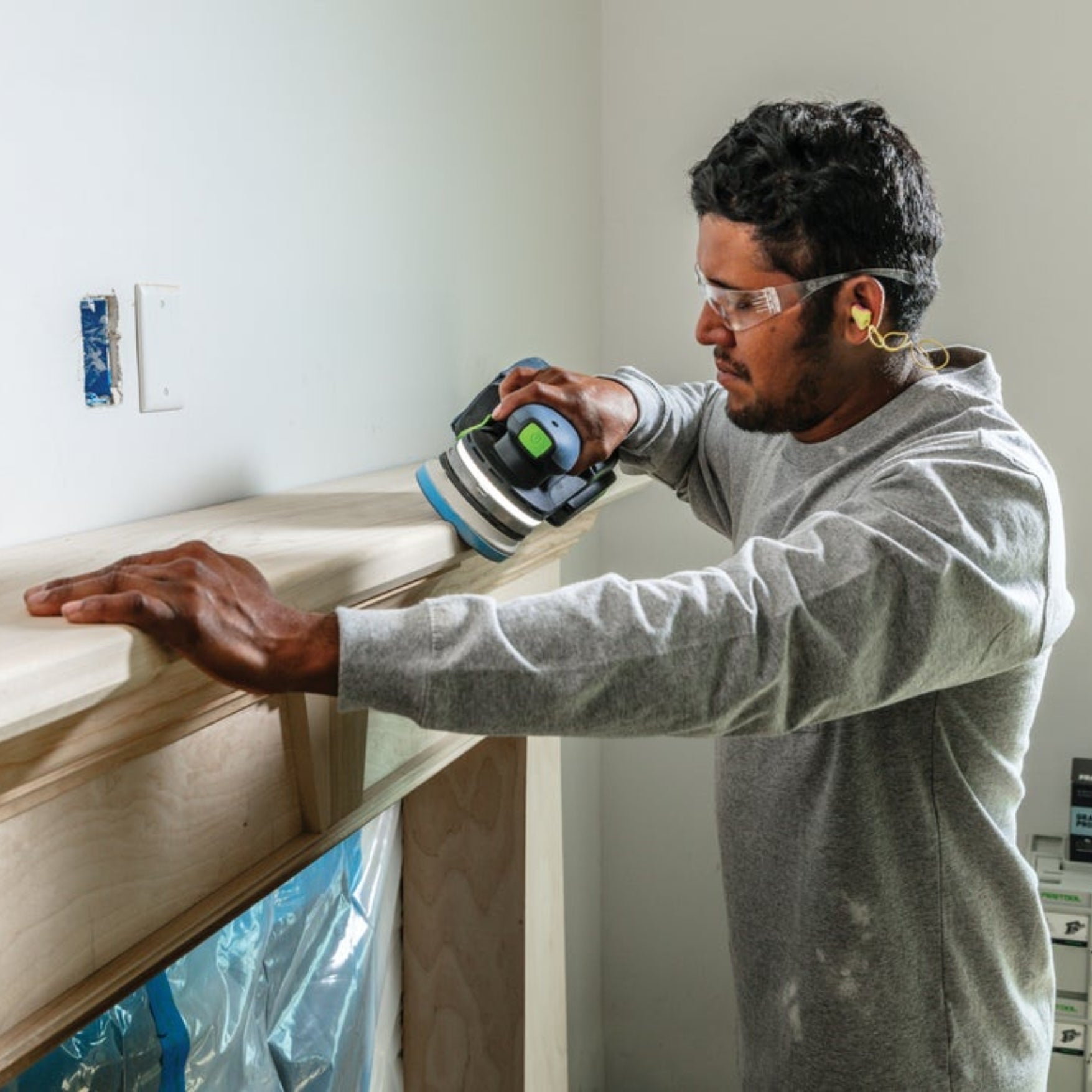 Man using Festool sander with Festool Grit Abrasives Granat PROfile D125 M GR PRO to sand wooden mantel