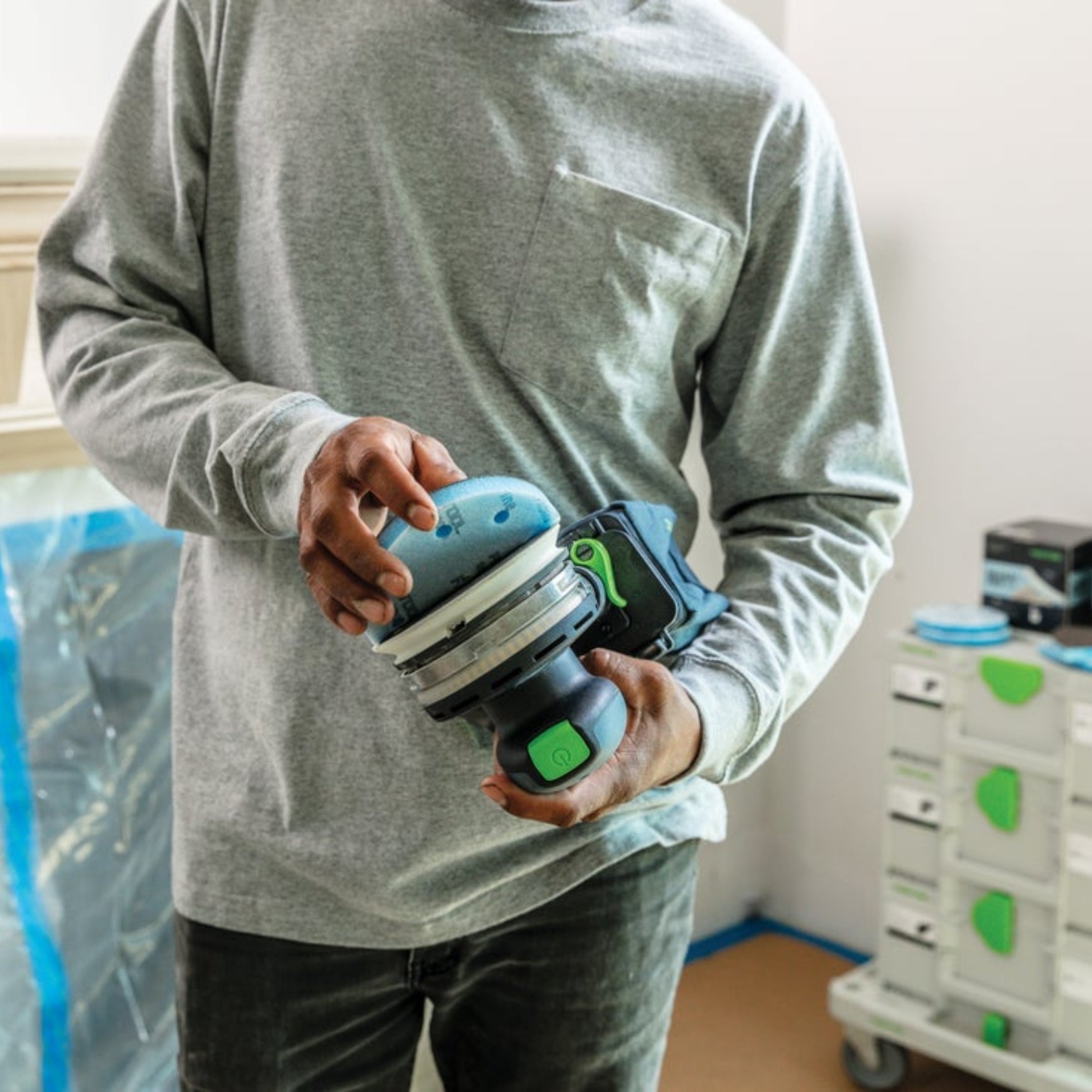 Man holding Festool Grit Abrasives Granat PROfile D125 M GR PRO close to Festool sander