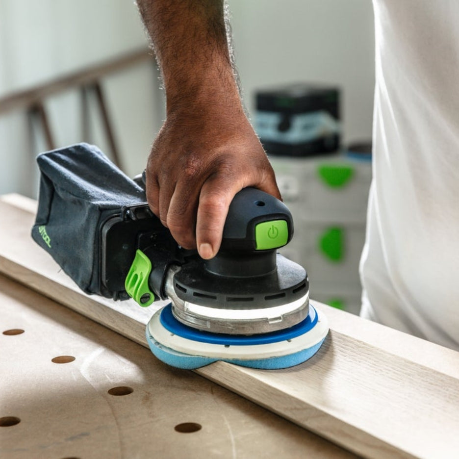 Man sanding a piece of wood using a Festool sander and Festool Grit Abrasives Granat PROfile D150 M GR PRO