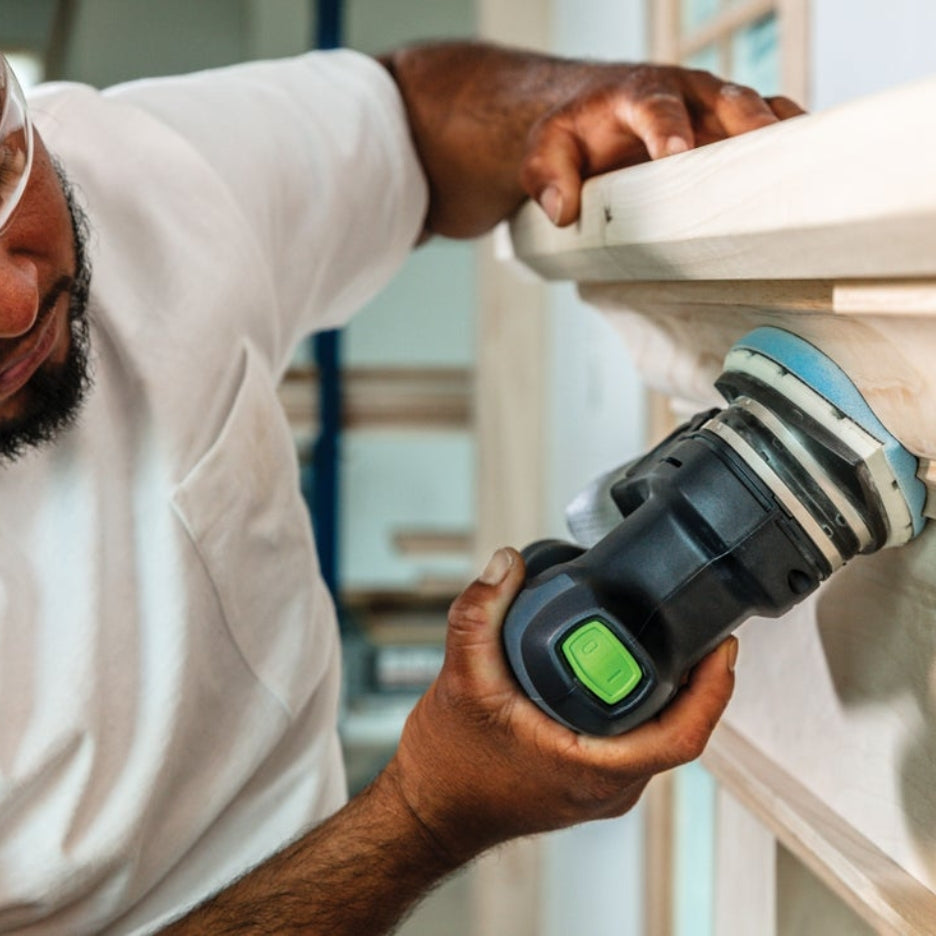 Close up at man sanding fireplace mantel using cordless Festool sander with Festool Grit Abrasives Granat PROfile Delta M GR PRO 