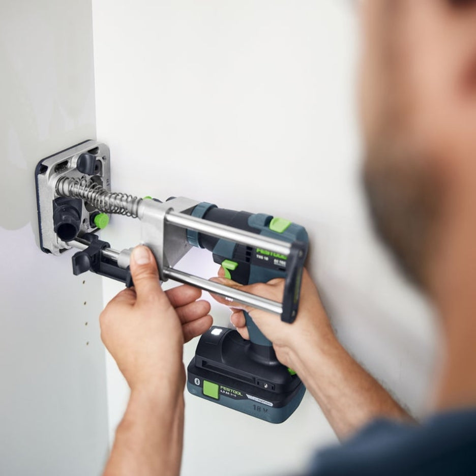 Person using a cordless drill attached to Festool Mobile Drilling Attachment MB 40 on a white wall