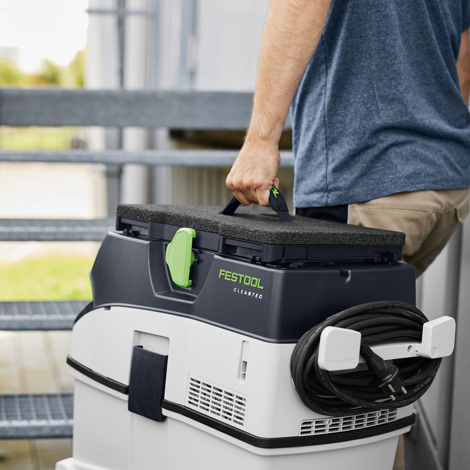 Man carries Festool Seat Cushion and CT 36 Dust Extractor with comfortable padded handle.
