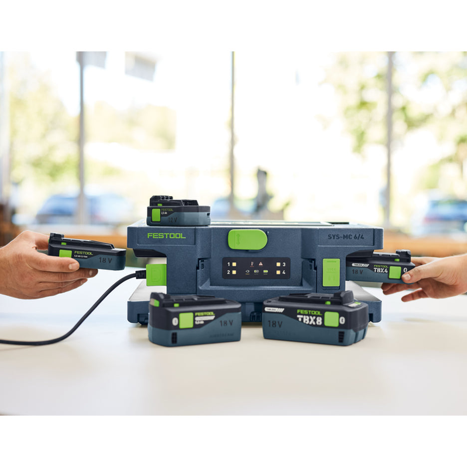 Festool Systainer Multi-Bay Rapid Charger  with batteries being inserted/removed, and sitting on and in front of it