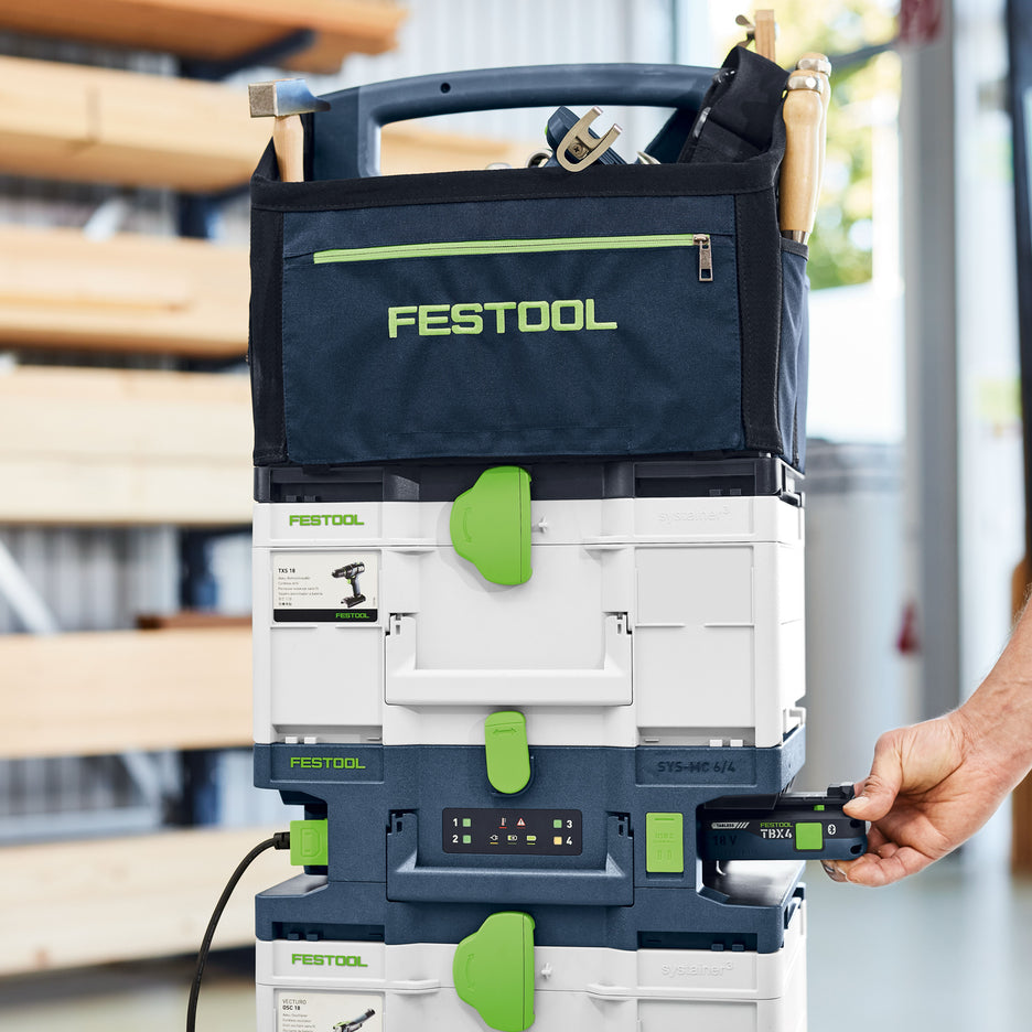 Festool Systainer Multi-Bay Rapid Charger in stack of Systainers as a man inserts a battery to charge
