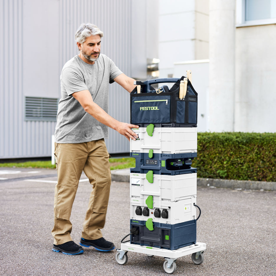Festool Systainer Multi-Bay Rapid Charger in stack of toolboxes on dolly being rolled through parking lot