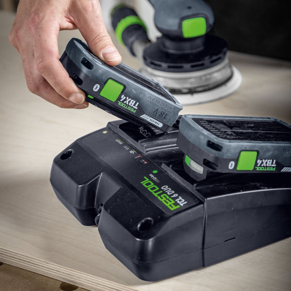 Hand inserting Festool Tabless Battery into charger