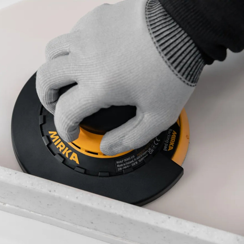 Hand holding DEROS sander with Edge protector attached