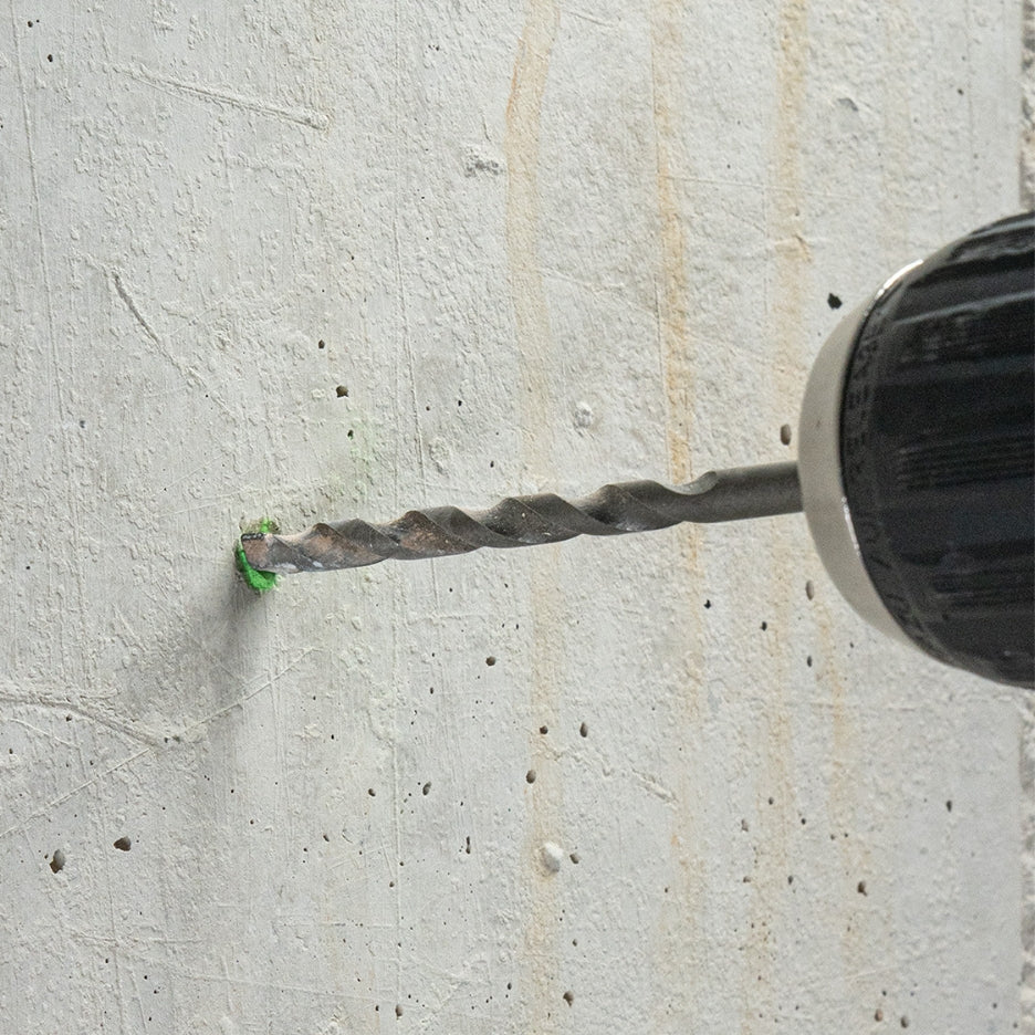 Drilling a hole on concrete, on top of mark made using Pica Powder Marker 