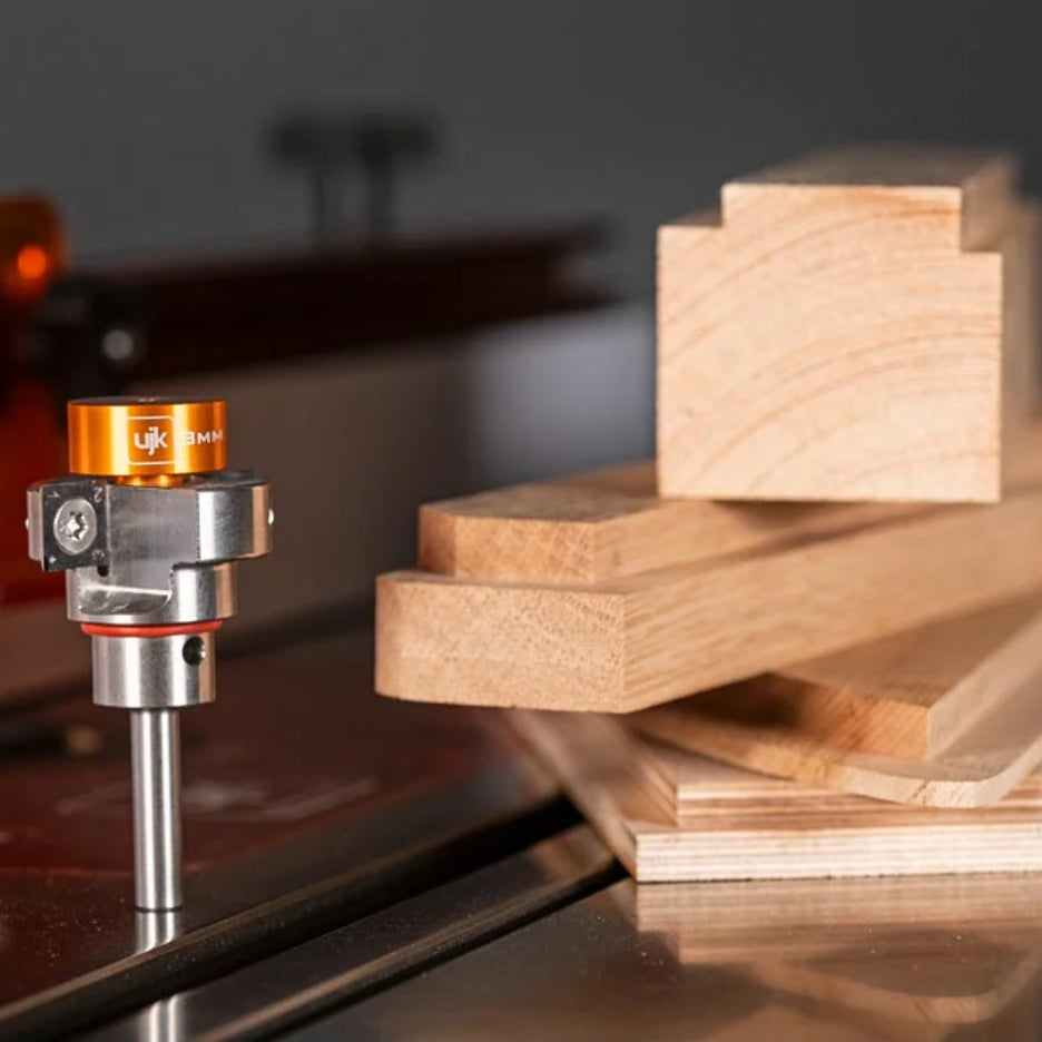 UJK Tools 2-Flute Metric Multi-Rabbetting Router Bit with 1/2 Inch Shank on a table with wooden pieces in the background