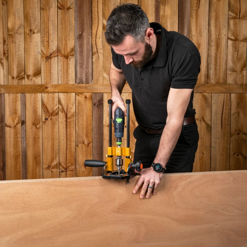 Man using Drill Guide with 10mm Chuck on a wooden surface with a wooden wall background