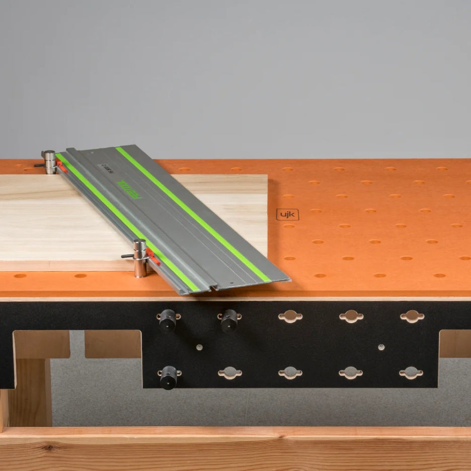 Woodworking table with UJK Tools Isometric HDF Valchromat Top , bench dogs, and a guide rail on top