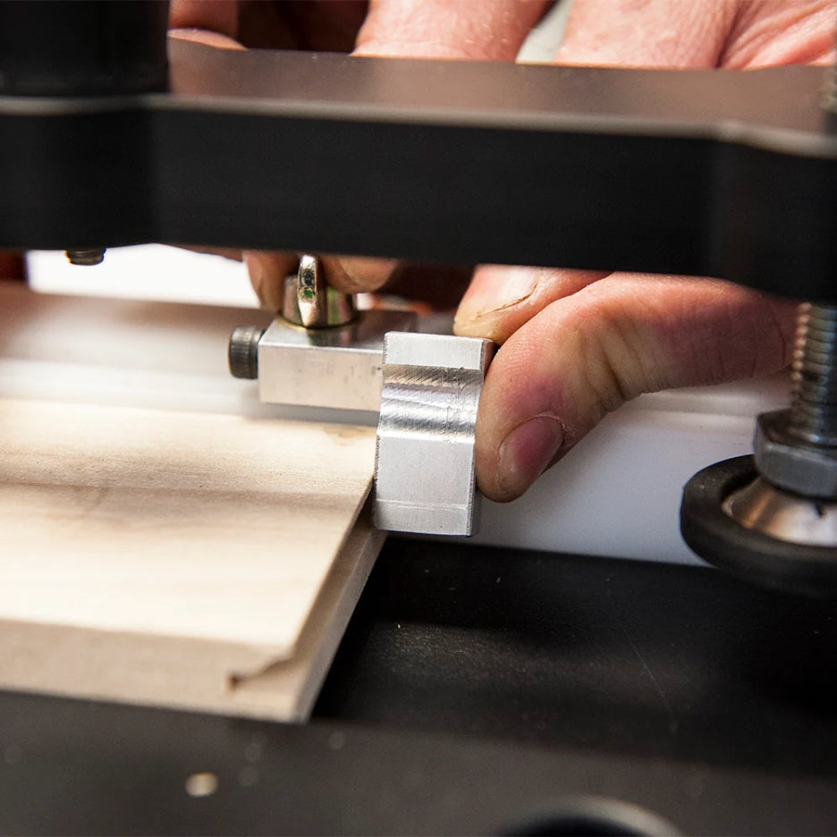 Close-up of a person using UJK Tools Professional Coping Sled on a piece of wood.