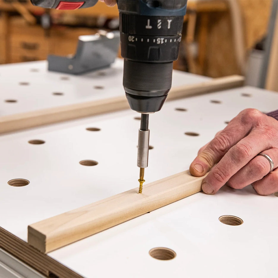Person using a drill to attach a screw on the back of a UJK Tools Rail Clamp MFT Top