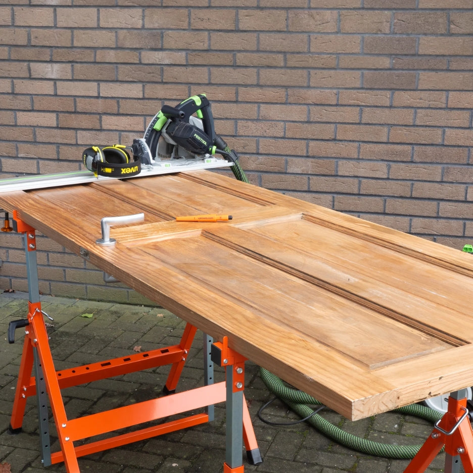 Wooden door on UJK Tools Trestle with a circular saw against a brick wall.