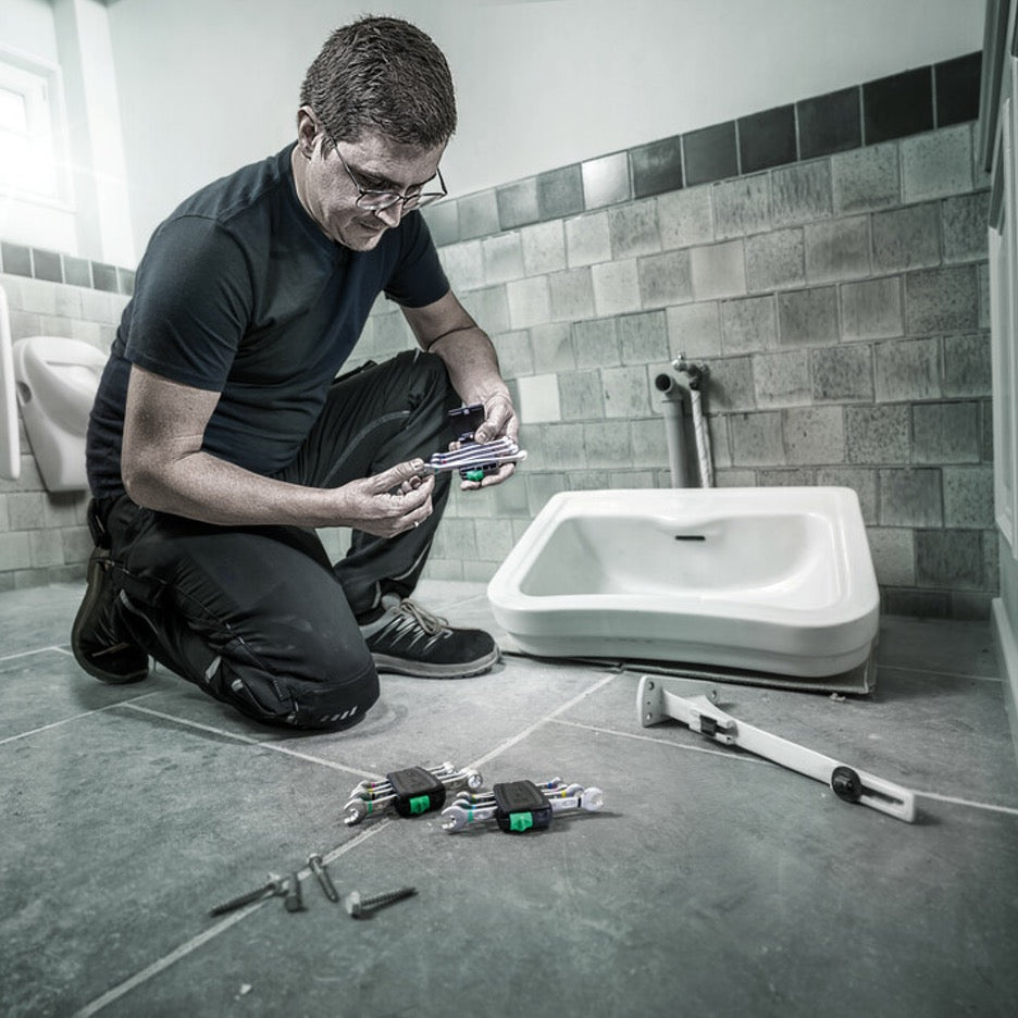 Plumber selects wrench to install sink hardware.