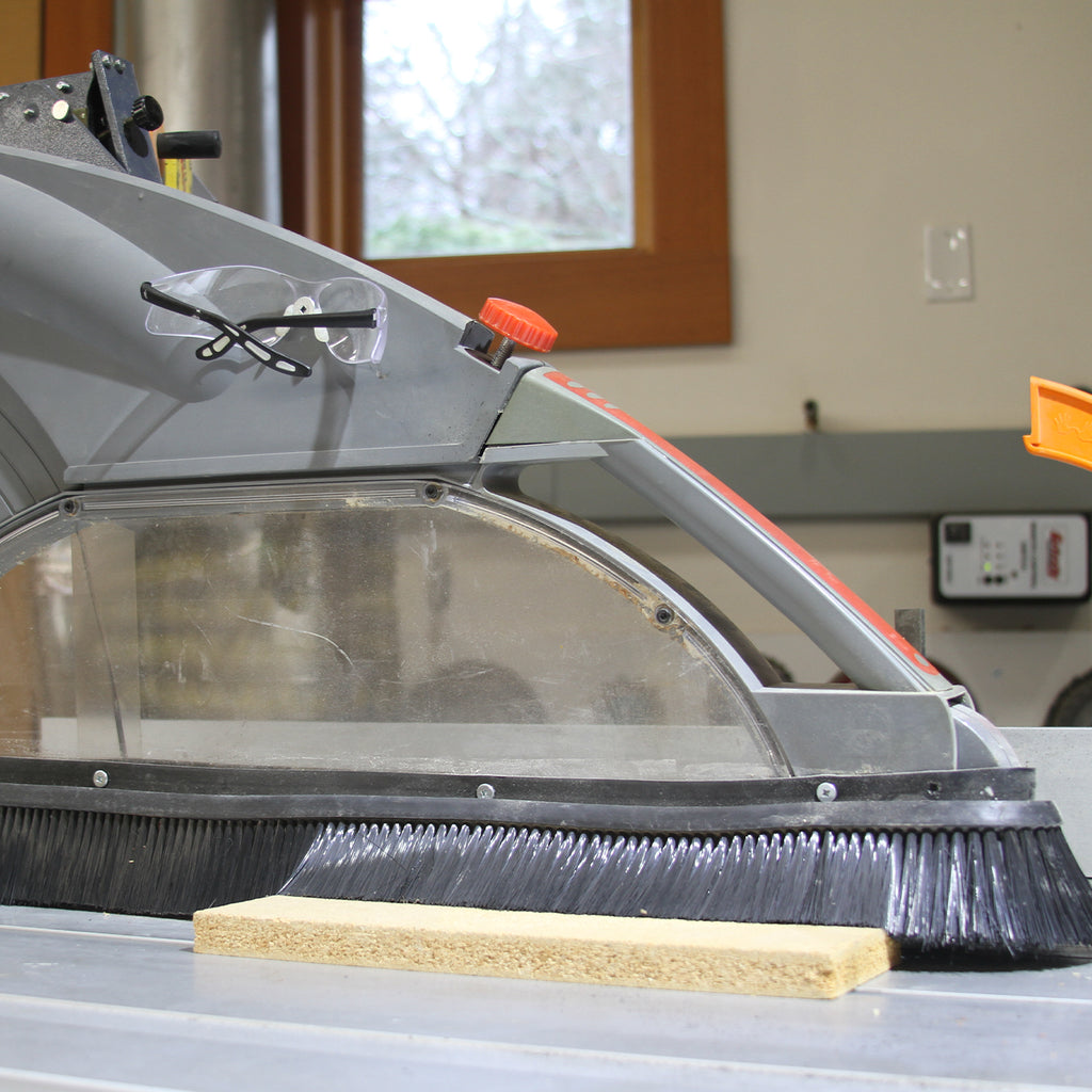 Saw Stache riveted to the overhead blade guard of a sliding table saw to focus vacuum suction around the blade.