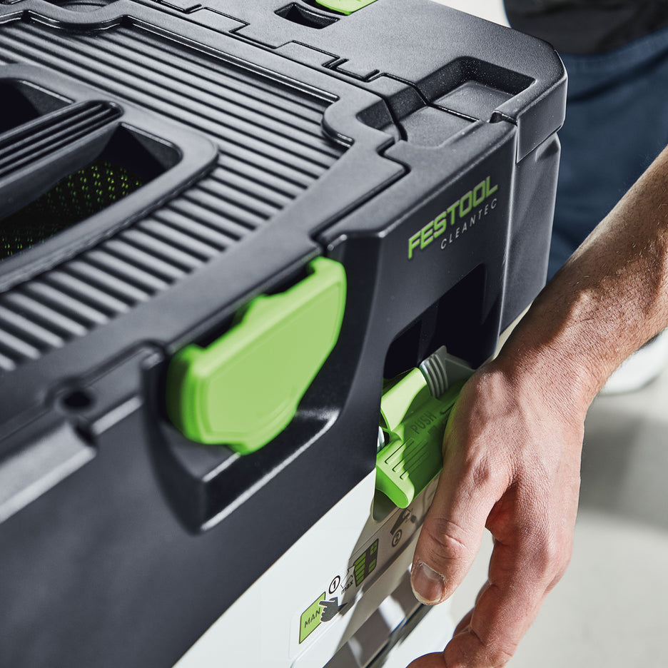 Man pushes down on the external filter cleaning lever of the Festool CTC MIDI I Dust Extractor.