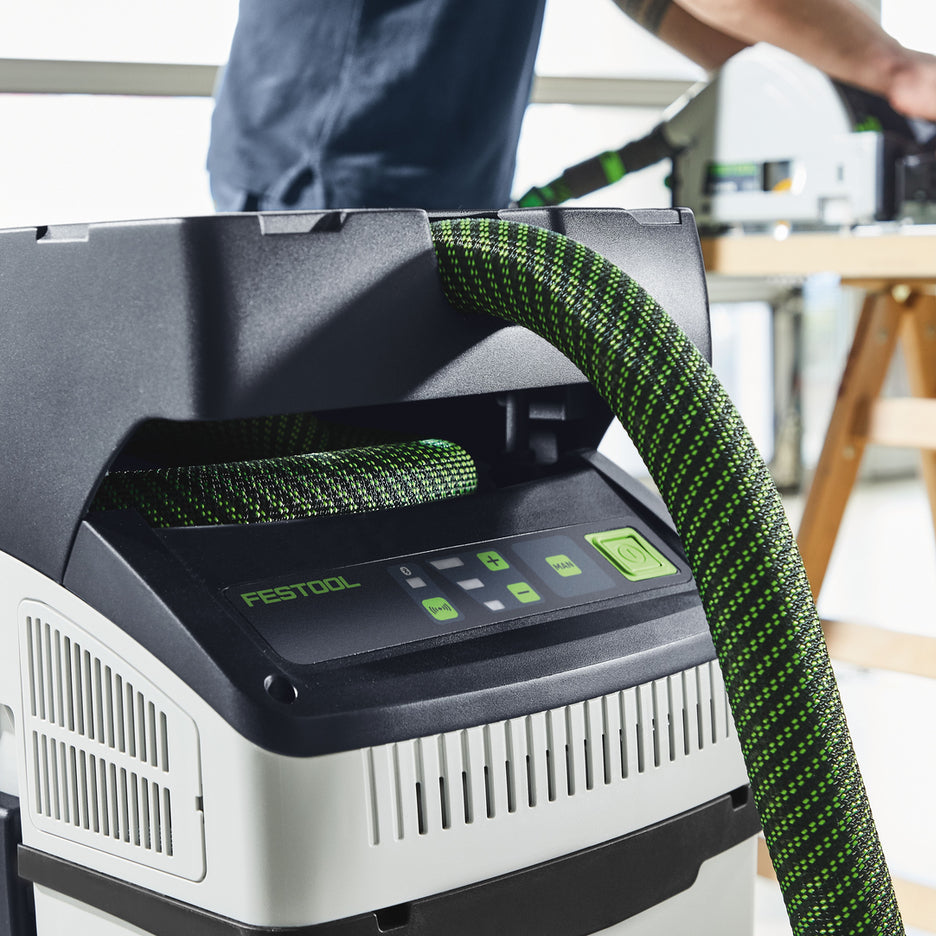 Worker uses a Festool CTC MIDI I Dust Extractor connected to cordless plunge cut track saw.