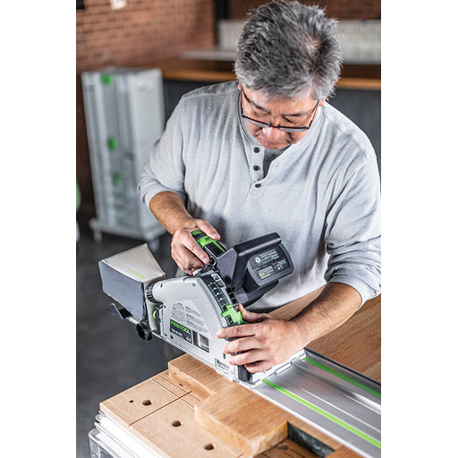 A man adjusts the depth stop of the TSC 55 KEB cordless track saw before cutting thick lumber.
