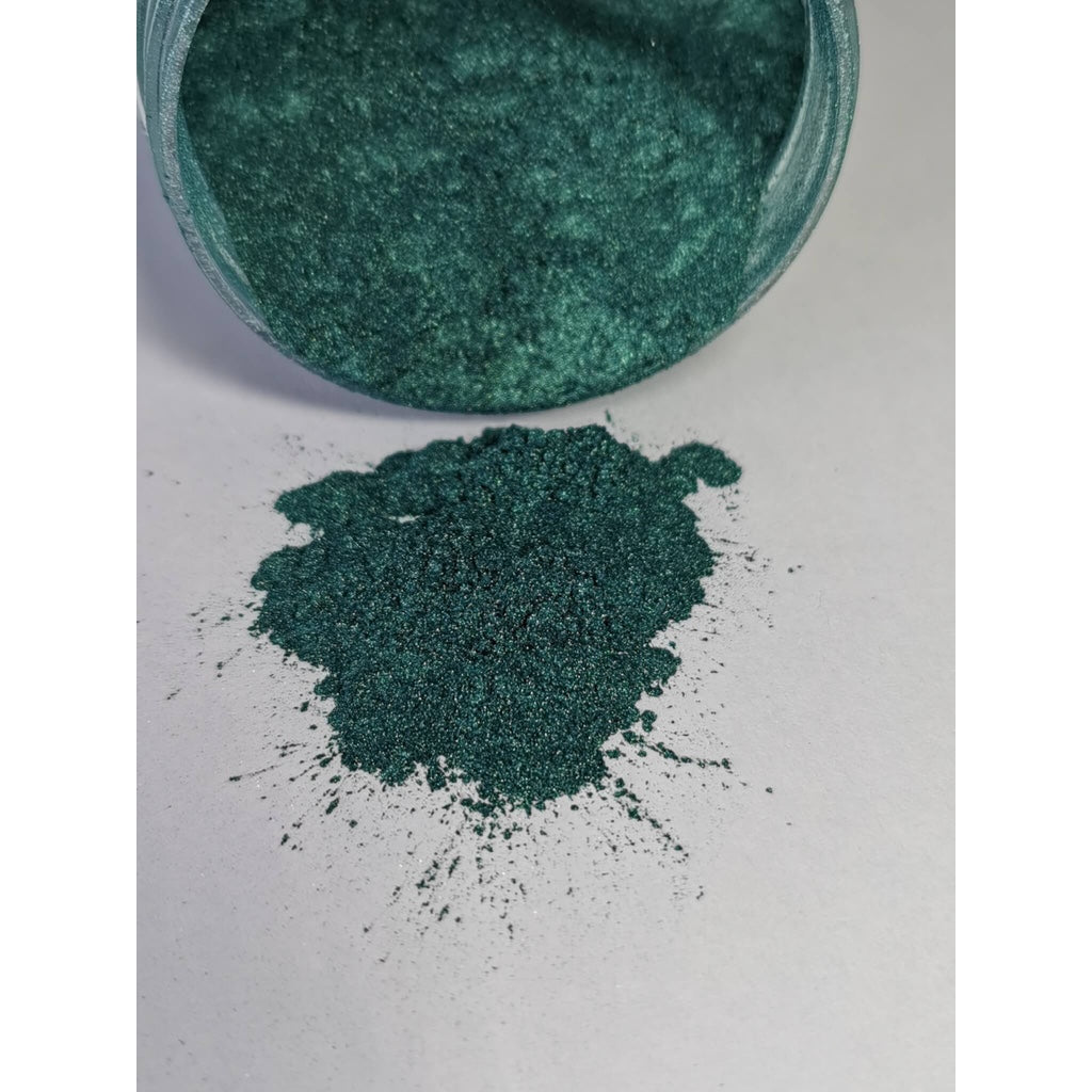 A jar of Blackish Green Ryver Epoxy Aurora Metallic Pigment on its side showing the actual colour and consistency of mica.