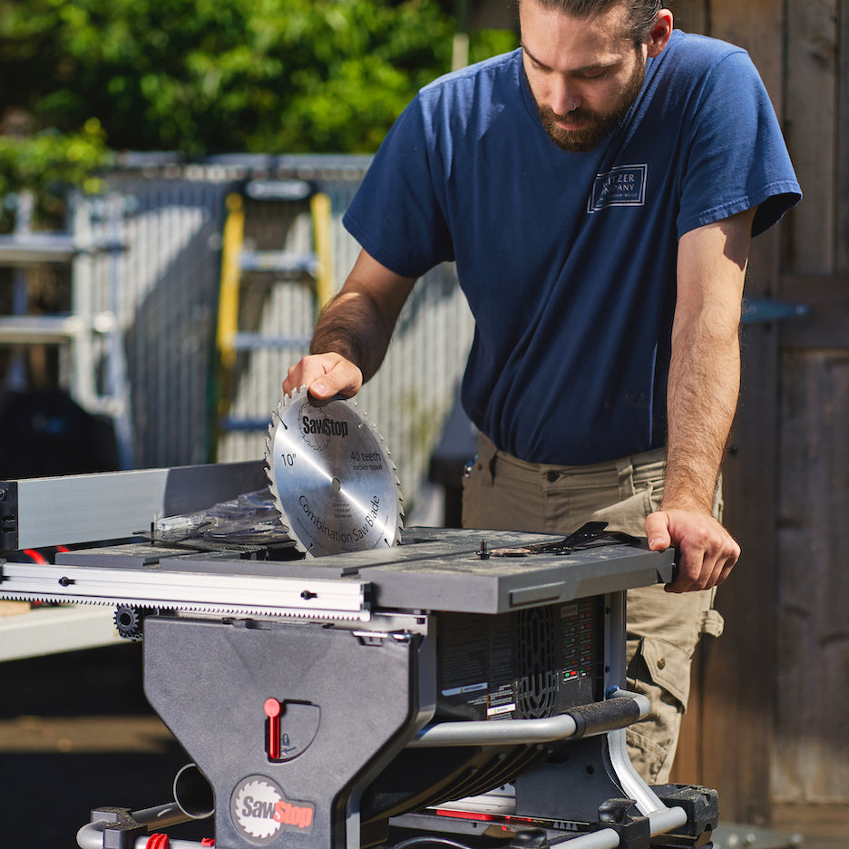 Man changes saw blade of SawStop Compact Table Saw.