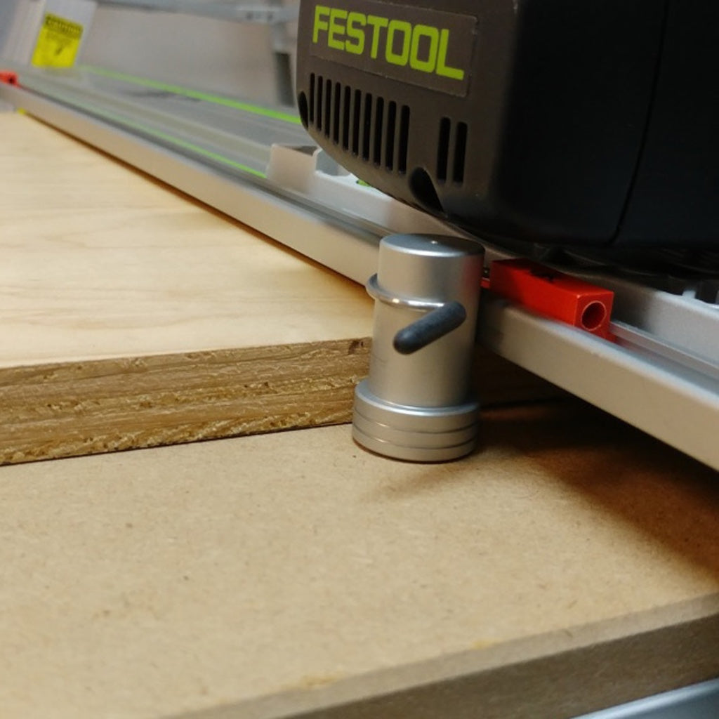 The motor of a Festool track saw with blade plunged to cut 3/4" plywood glides along a rail over top of a Stubby Dog.